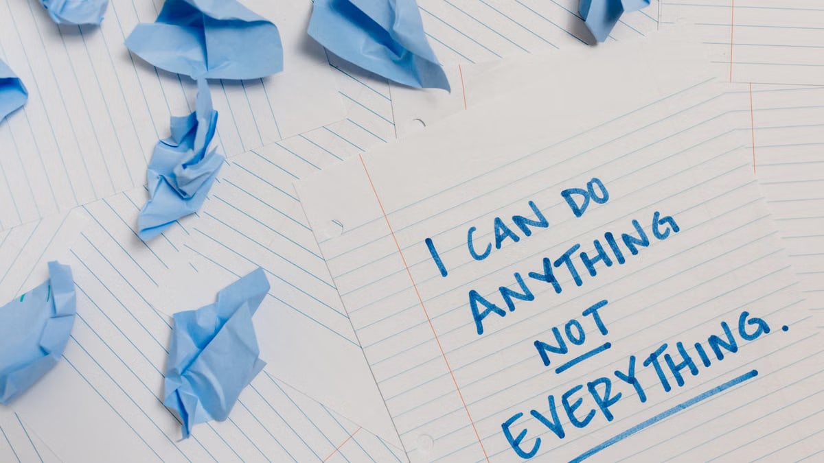 Inspirational quote on paper surrounded by crumpled blue sheets, conveying motivation.